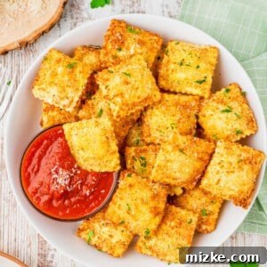 Overhead view of crispy ravioli in bowl with marinara