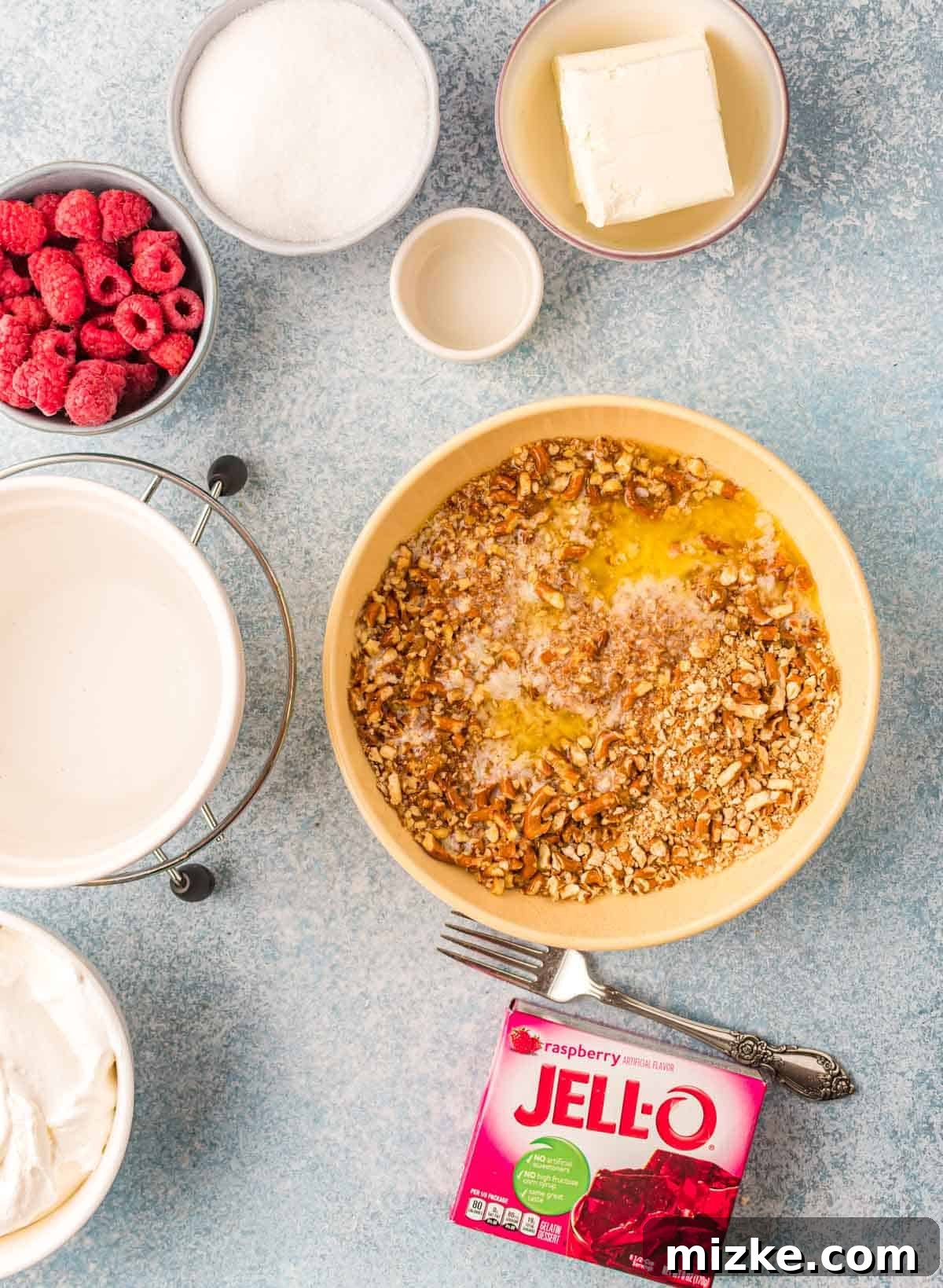 Raspberry Pretzel Delight 3 Crushed pretzels and melted butter in a bowl, alongside brown sugar – ingredients for the pretzel crust.