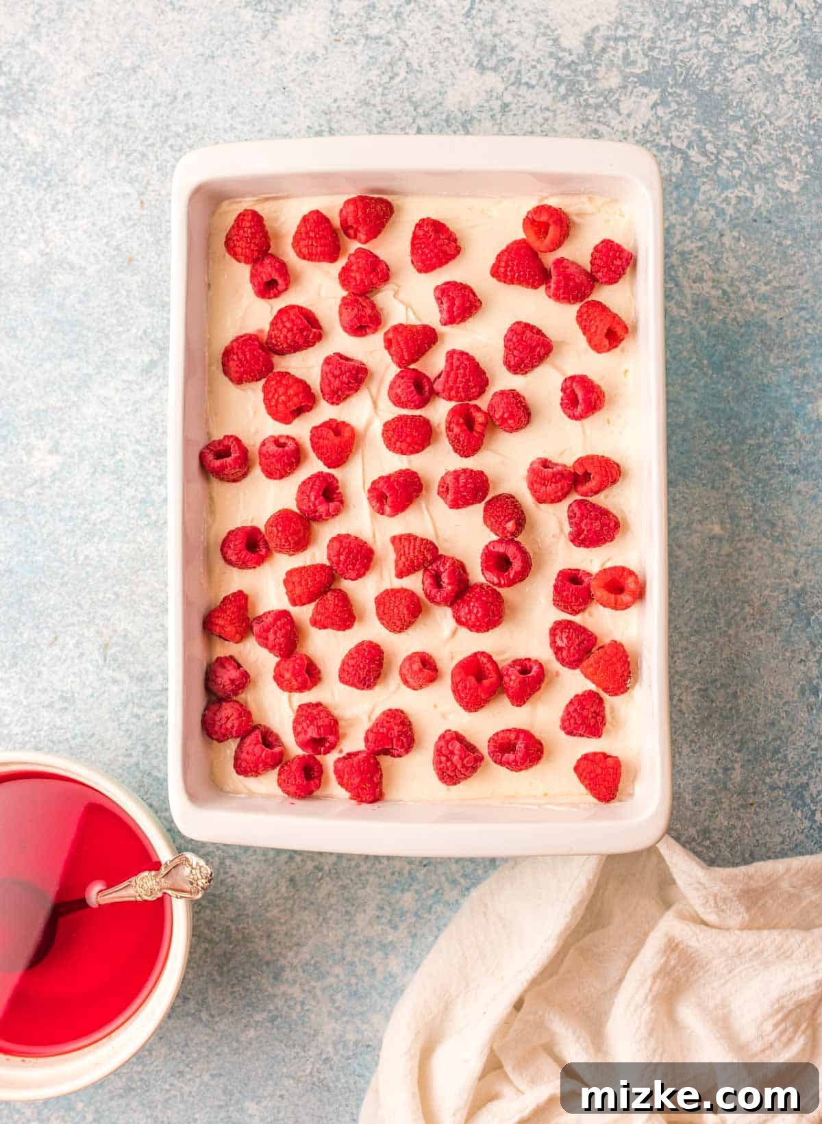 Raspberry Pretzel Delight 5 Fresh raspberries dotted on top of the cream cheese filling, next to a bowl of cooled Jello.
