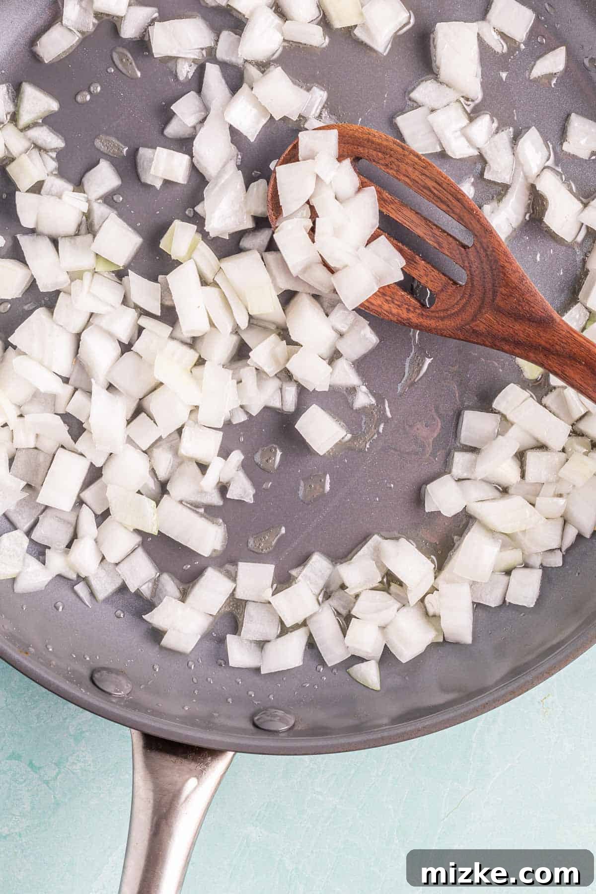 Spicy Tofu Chorizo 4 Diced white onion being sautéed in avocado oil in a grey skillet.
