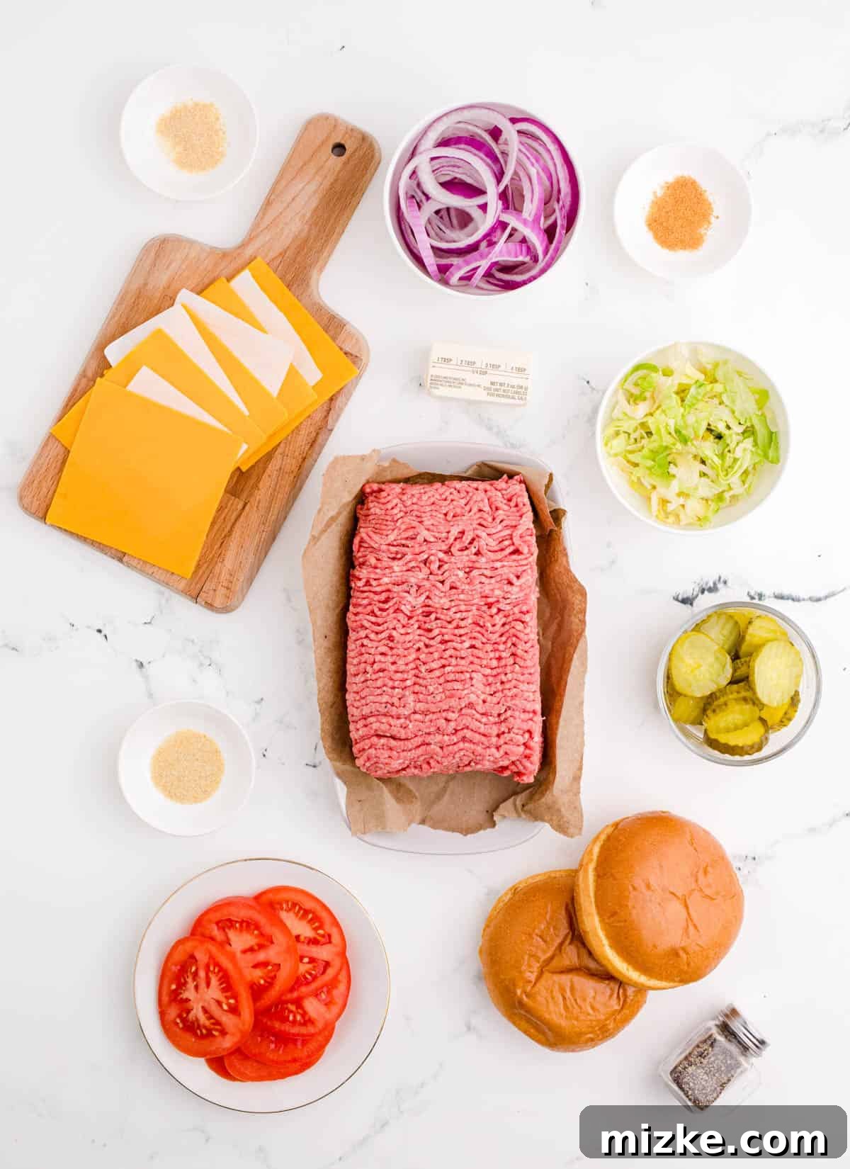 All the essential ingredients neatly arranged for making delicious smash burgers, including ground beef, butter, buns, cheese, and a variety of seasonings.