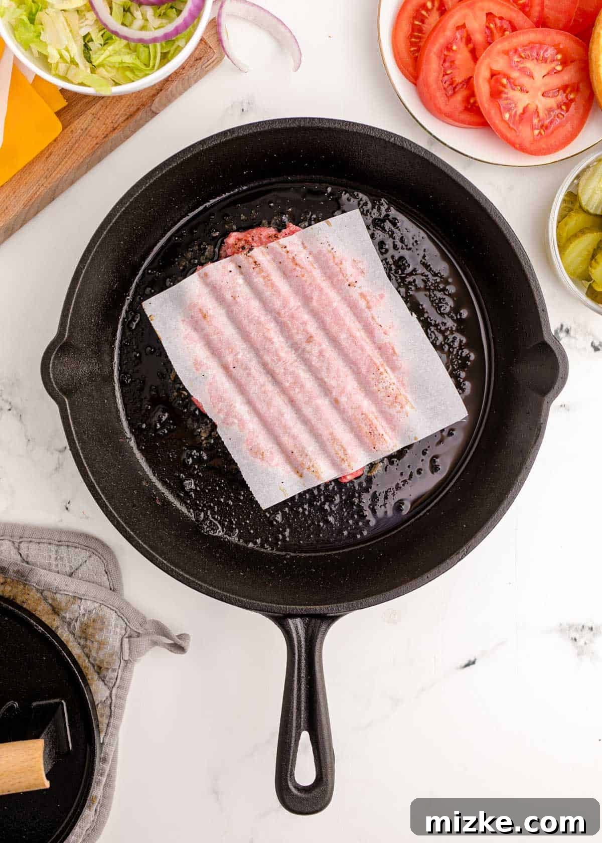 The impression left on a thin ground beef patty after being smashed flat with a meat mallet and parchment paper, showcasing its wide, thin, and textured form.