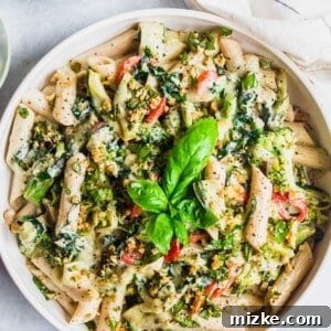 A serving of creamy vegan basil cashew pasta with fresh basil garnish.