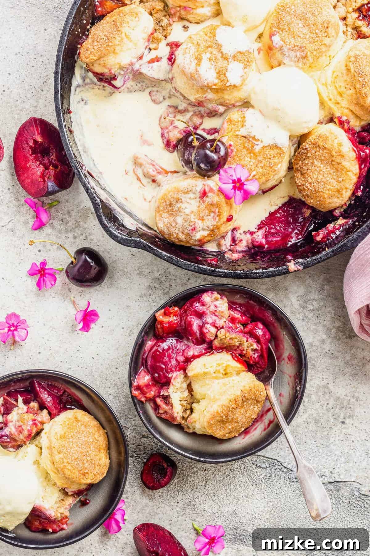 Generously Crusted Stone Fruit Cobbler 2 Biscuit-topped stone fruit cobbler in cast iron pan and two serving bowls