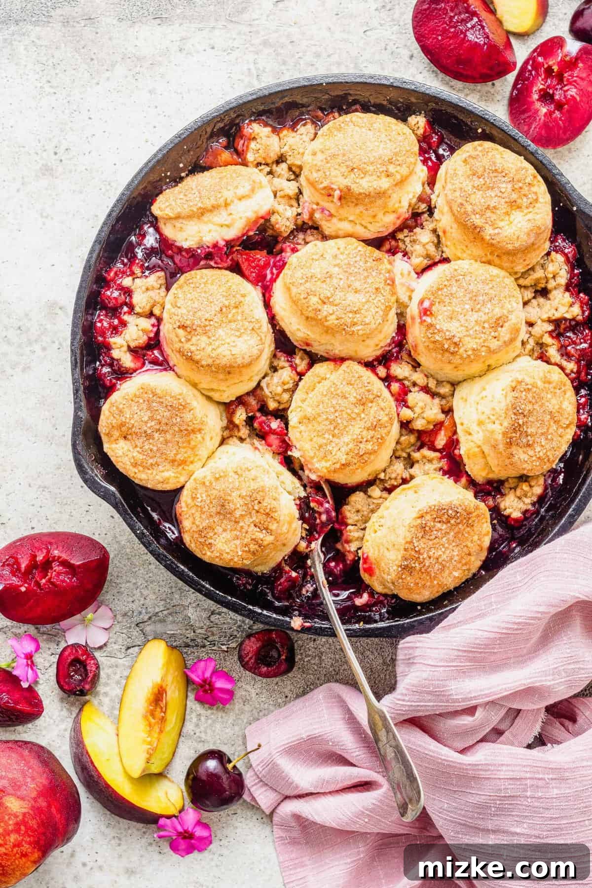 Generously Crusted Stone Fruit Cobbler 4 Overhead view of stone fruit cobbler with biscuit topping in cast iron skillet