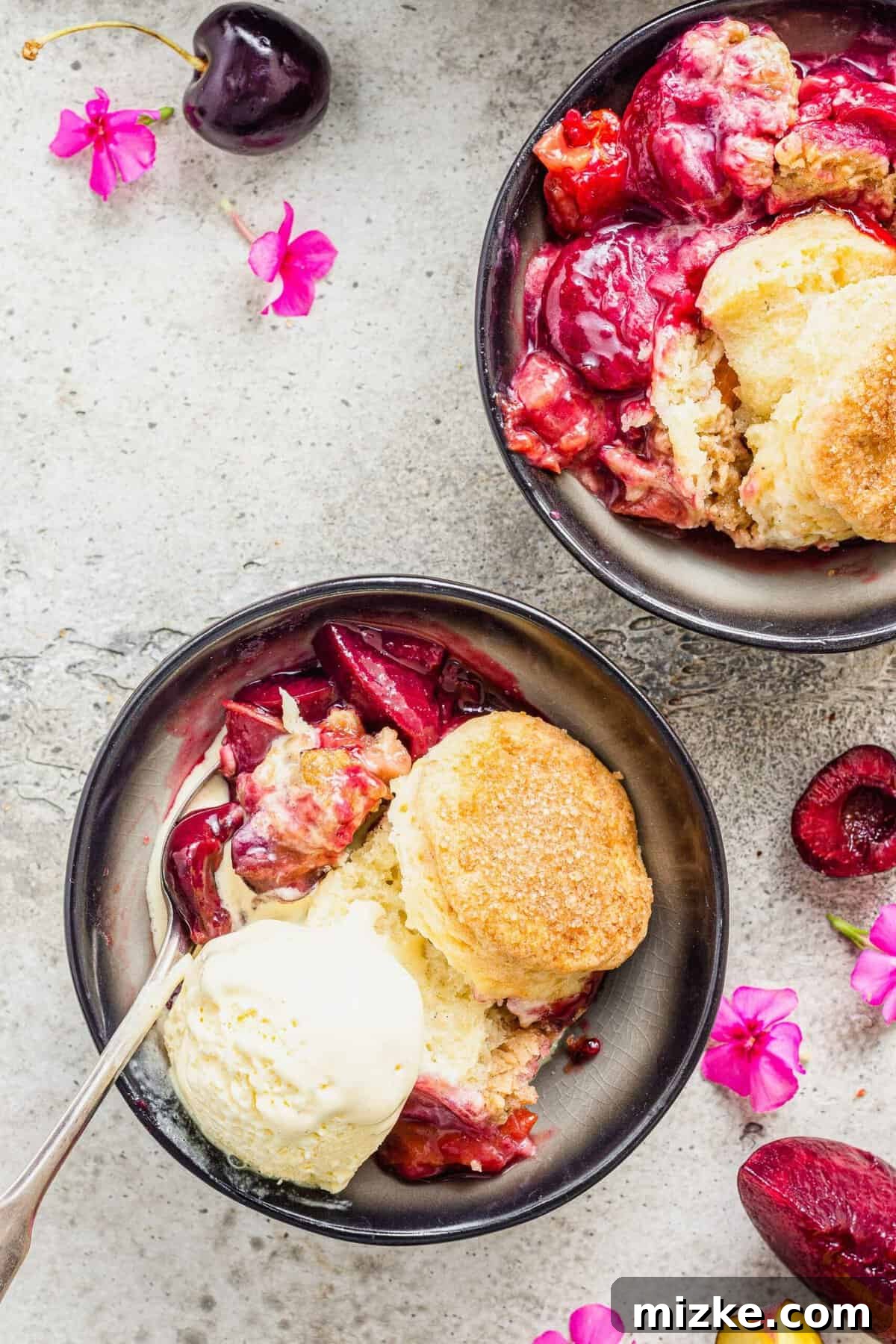 Generously Crusted Stone Fruit Cobbler 6 Overhead view of two bowls of stone fruit cobbler with biscuits