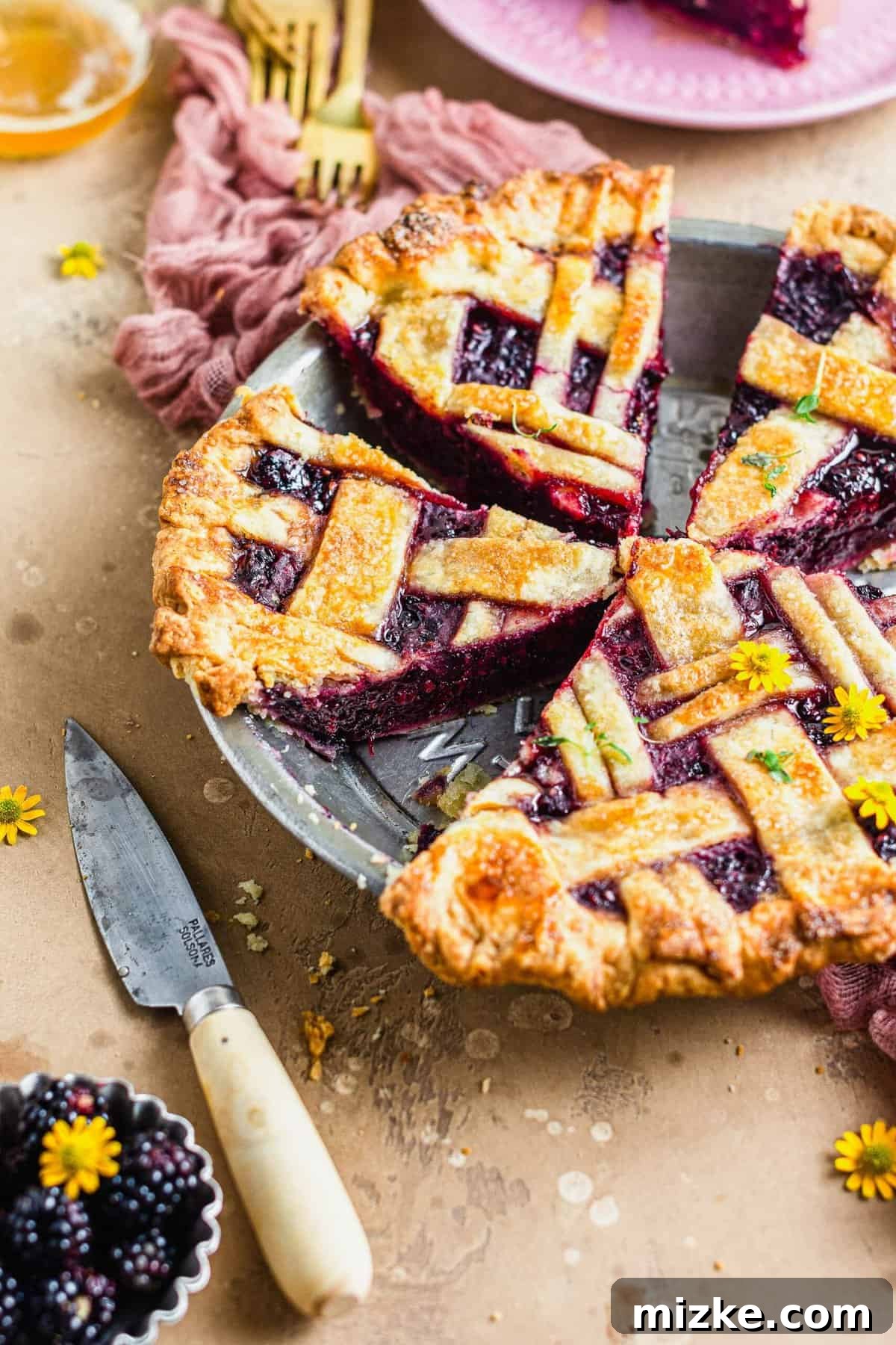 Thyme-Kissed Honey Blackberry Pie 5 A perfectly sliced blackberry pie in its plate, showing the rich filling and flaky crust.