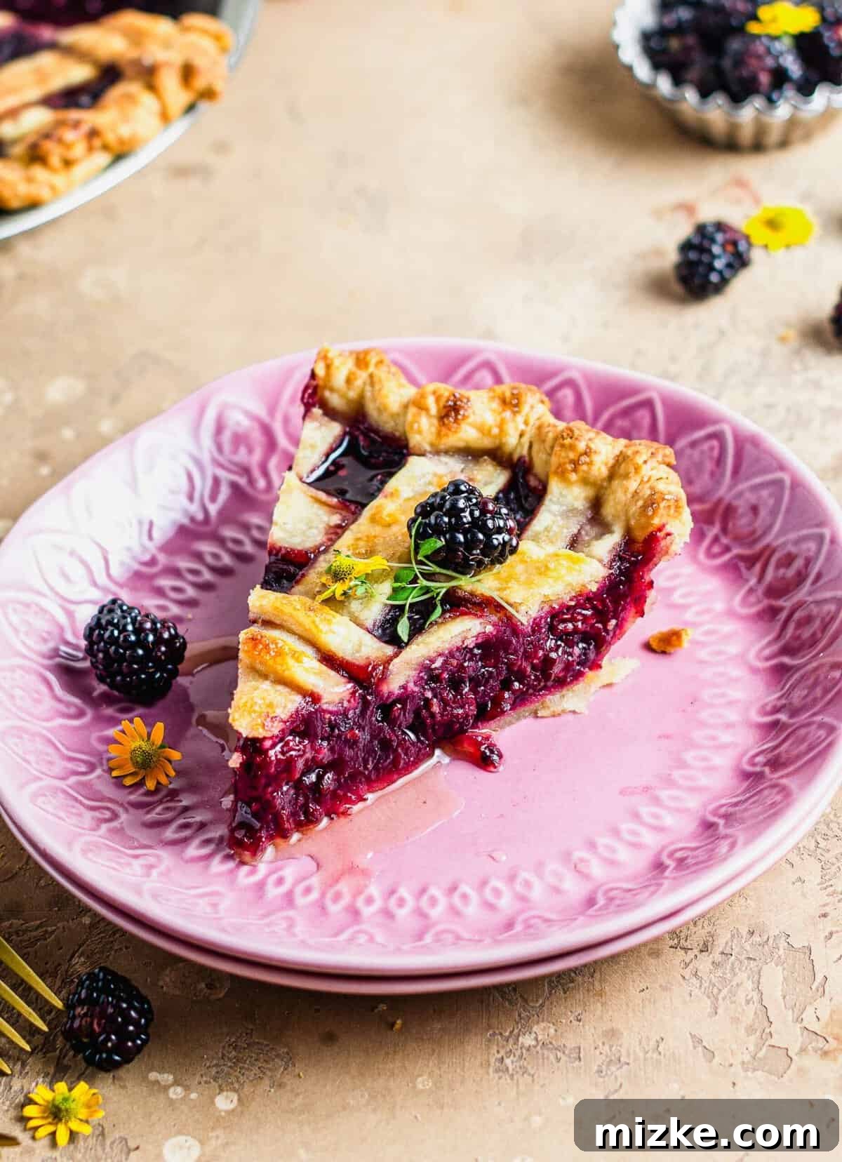 Thyme-Kissed Honey Blackberry Pie 6 A slice of blackberry pie with a beautiful lattice crust, served on a purple plate.