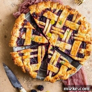 Overhead view of honey thyme blackberry pie cut in pie plate