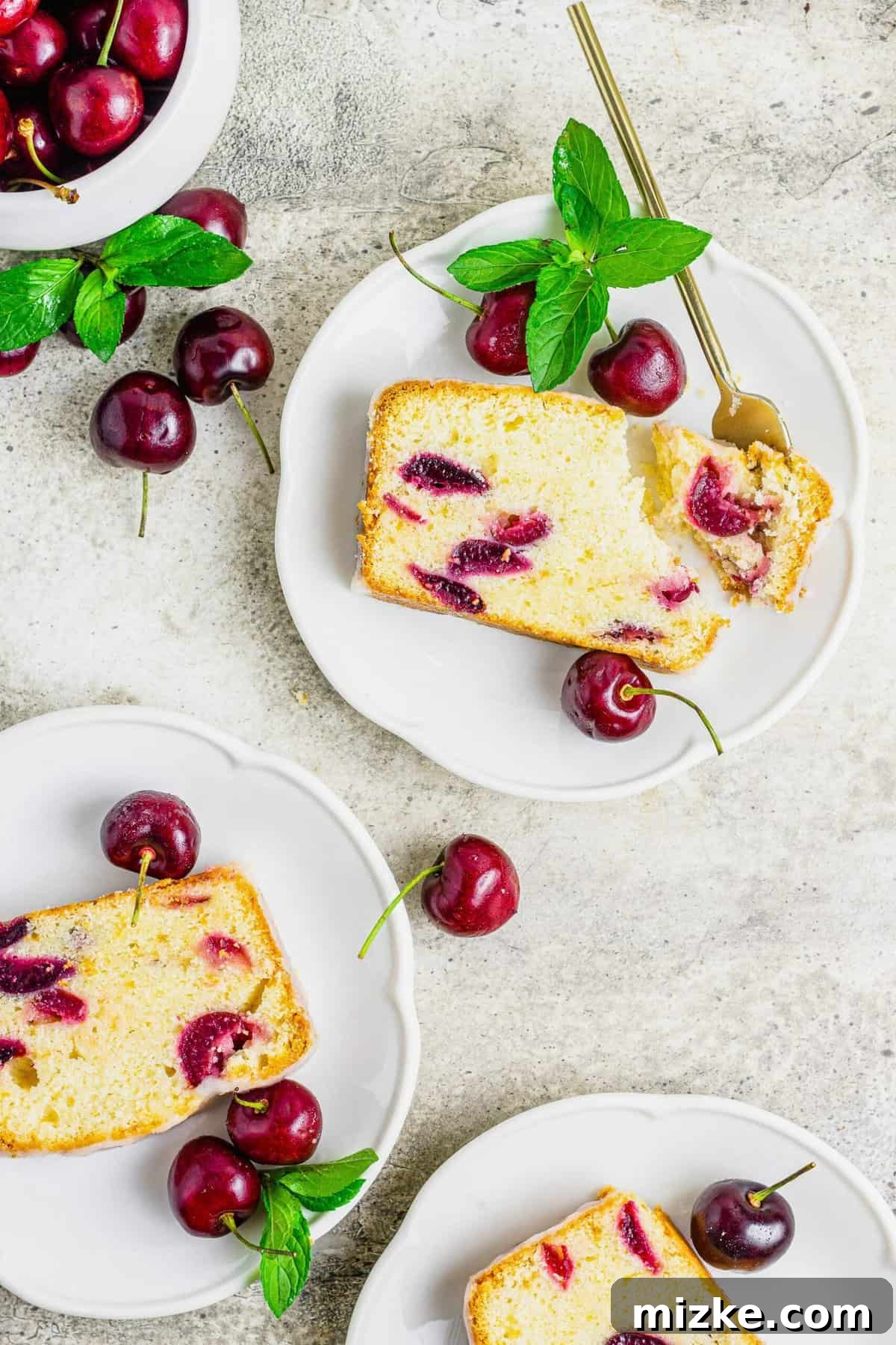 Velvet Cherry Amaretto Loaf 4 Three individual plates, each presenting a delightful slice of cherry amaretto loaf cake, artfully arranged with a scattering of fresh, whole cherries on a dark background