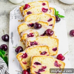 Sliced cherry amaretto loaf cake on rustic cutting board