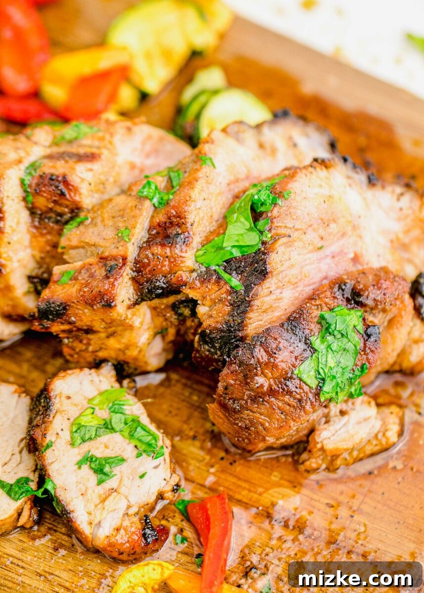 Succulent Grilled Pork Medallions 4 Sliced and garnished pork tenderloin is resting on a wooden cutting board.