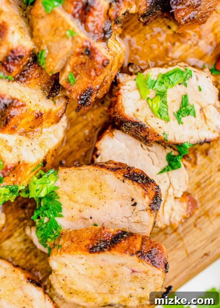 Succulent Grilled Pork Medallions 5 Slices of pork tenderloin are presented on a wooden cutting board.