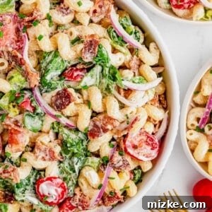 A close-up of a serving of BLT pasta salad, showcasing the pasta, bacon, lettuce, and tomatoes in a creamy ranch dressing.