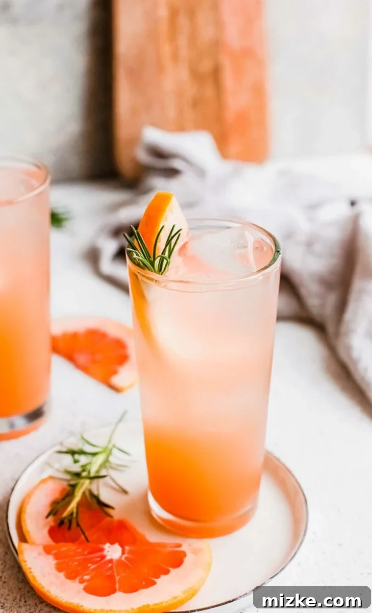 Bitter Sweet Gin and Tonic 3 A beautifully garnished glass of grapefruit gin and tonic with rosemary sprigs and a grapefruit slice.