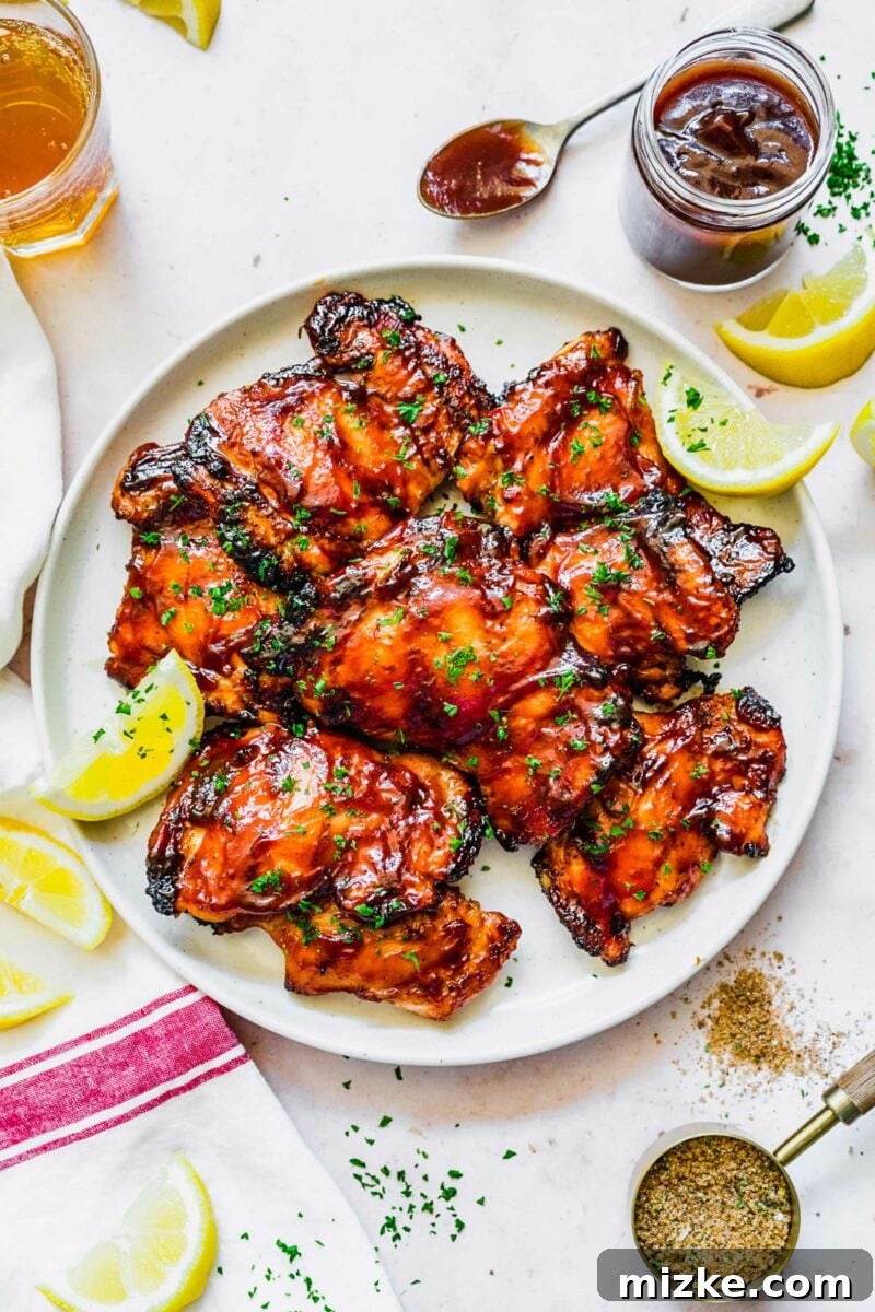 Classic Grilled BBQ Chicken 2 Perfectly grilled BBQ chicken thighs, glistening with sauce and a rich smoky char.
