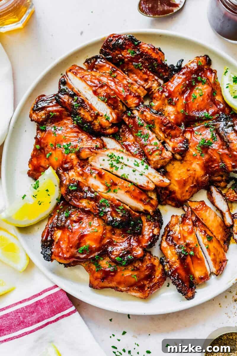 Classic Grilled BBQ Chicken 6 A vibrant plate of finished BBQ grilled chicken thighs with a side of fresh corn salad and dipping sauce.