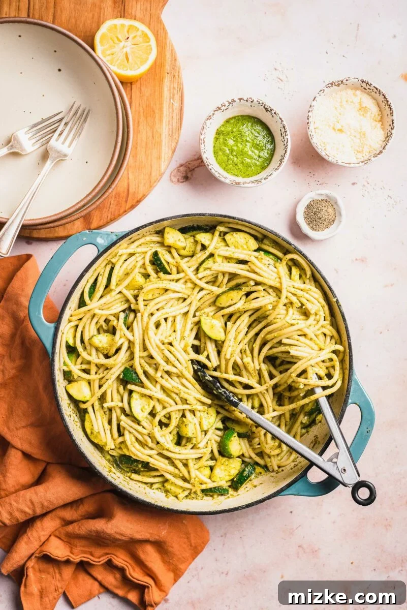 Velvety Lemon Zucchini Pasta 2 Tongs are placed in a large pot filled with creamy lemon zucchini pasta, ready to be served.