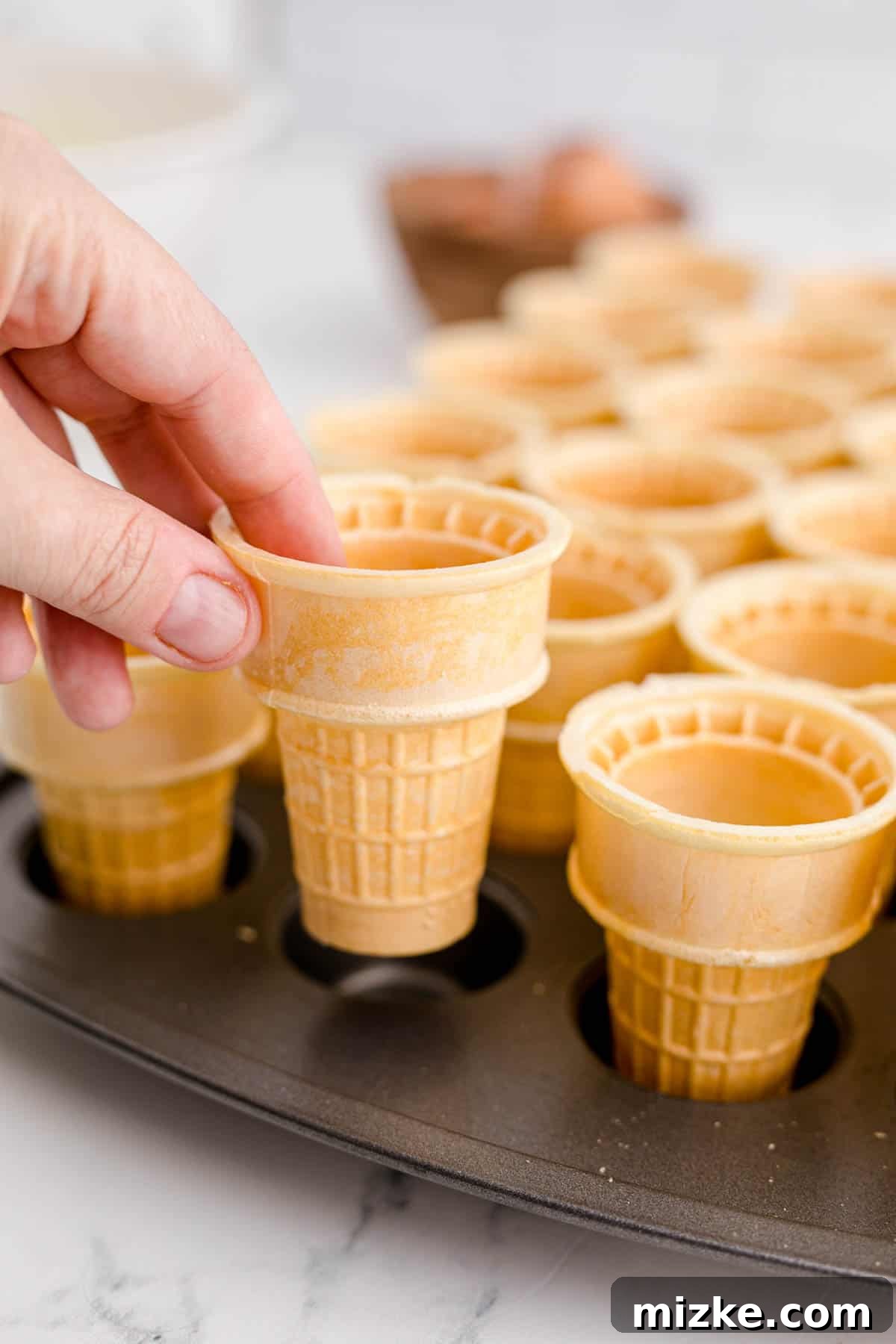 Waffle Cone Cupcakes 7 Carefully placing flat-bottomed ice cream cones into the compartments of a mini muffin tin.