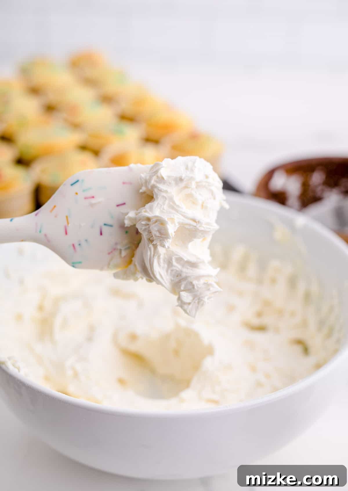 Waffle Cone Cupcakes 10 A white silicone spatula showcasing a dollop of perfectly whipped buttercream frosting, indicating ideal texture.