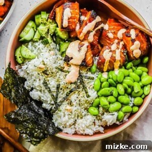 A close-up image of a vibrant salmon rice bowl, showcasing the cooked salmon, white rice, and fresh toppings.