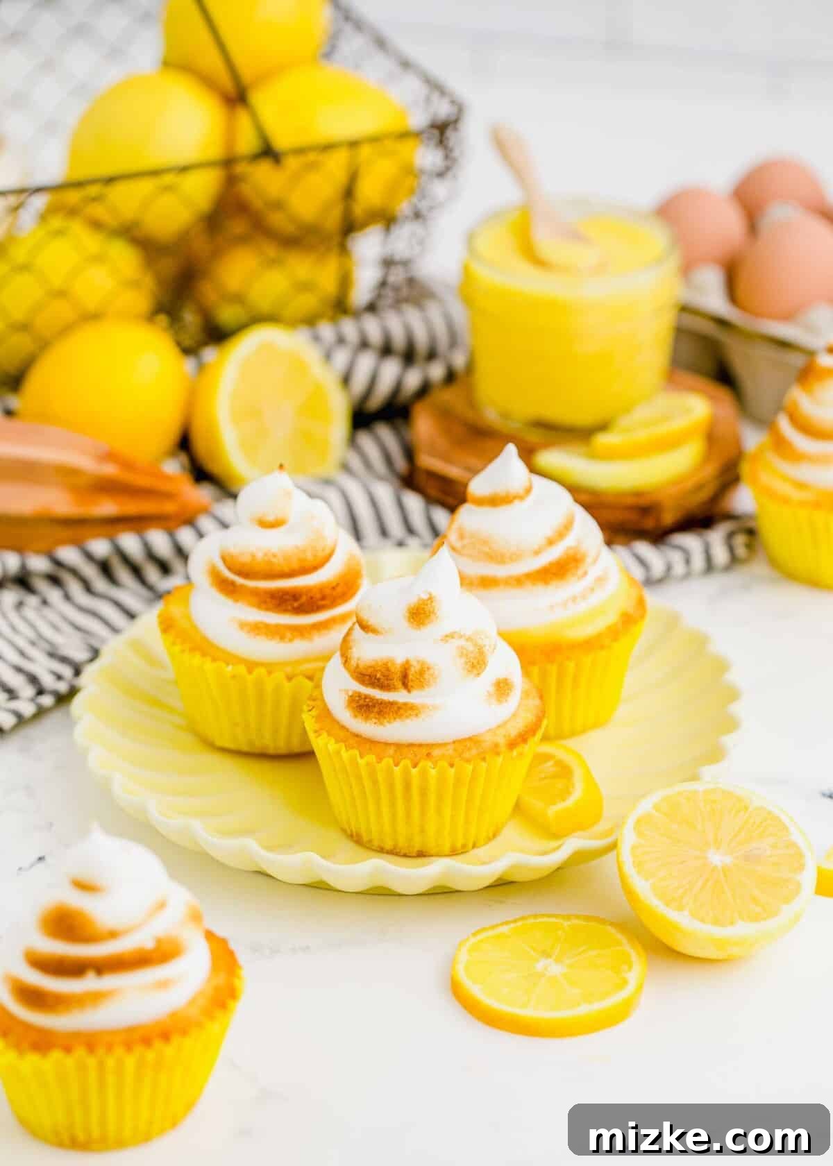 A plate featuring three perfectly golden and toasted lemon meringue cupcakes, ready to be enjoyed.