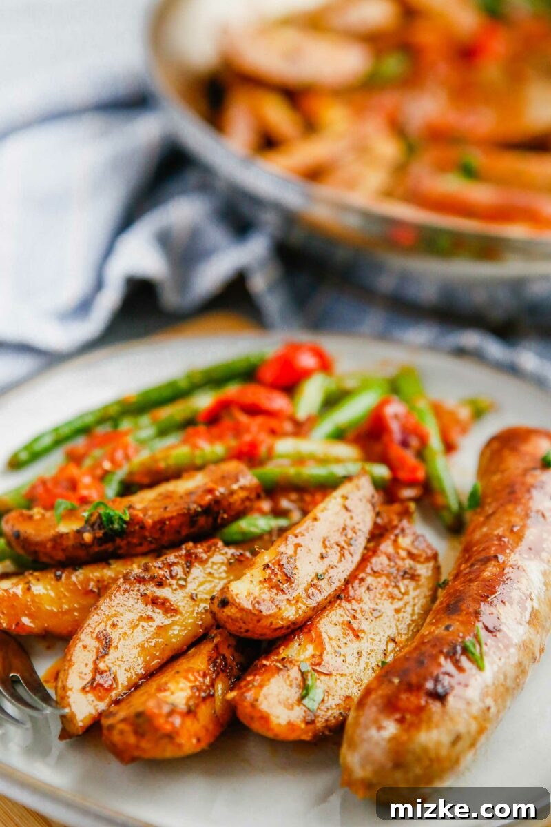 Easy Sheet Pan Sausage and Roasted Vegetables 4 Sausage and vegetables cooking in a single pan, showcasing the one-pan cooking method.