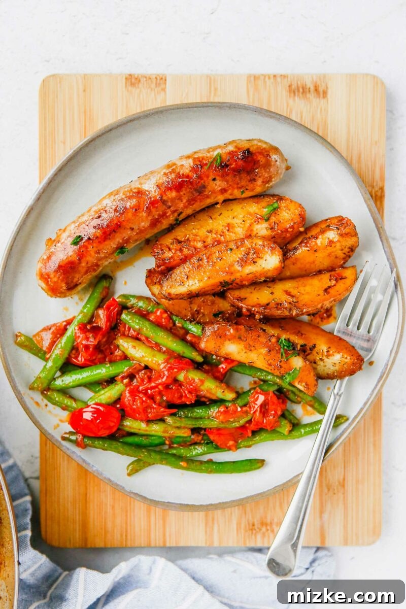 Easy Sheet Pan Sausage and Roasted Vegetables 5 A serving of One-Pan Sausage and Vegetables, garnished with fresh parsley.
