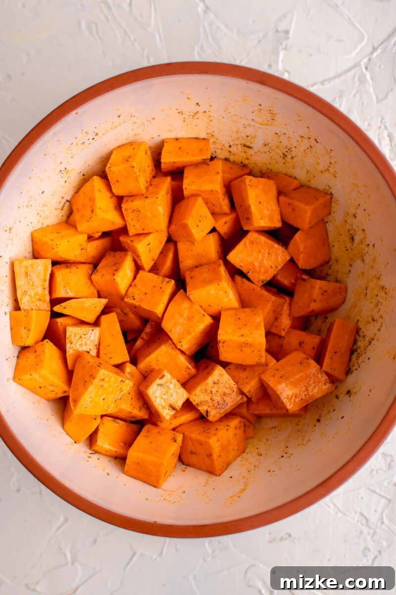 Zesty Golden Drumsticks 6 cubed sweet potatoes in a ceramic bowl with seasonings on top