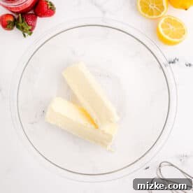 Two sticks of room temperature butter in a clear bowl, ready to be beaten for frosting