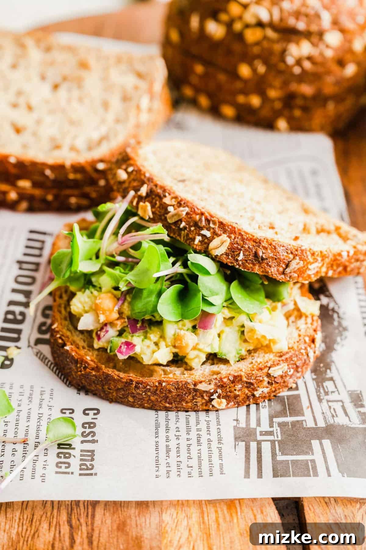 Delicious Smashed Chickpea Sandwich for Healthy Eating A single, perfectly made smashed chickpea sandwich with bread slices blurred in the background, highlighting the fresh filling.