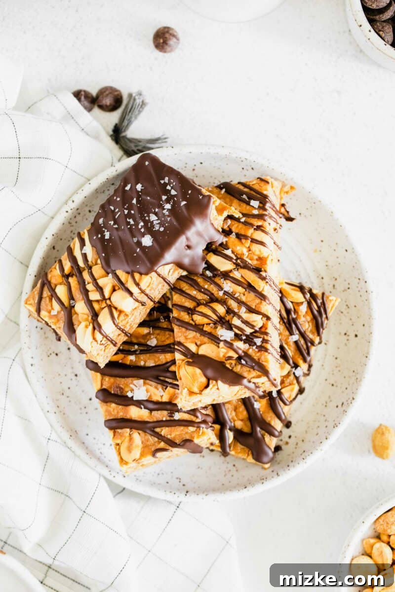 Chocolate Peanut Power Bars 2 Several homemade chocolate and peanut granola bars are artfully arranged on a speckled white plate, highlighting their rustic charm and delicious texture.
