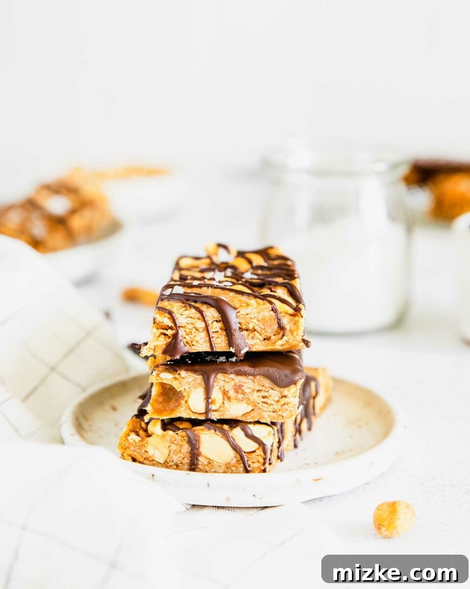 Chocolate Peanut Power Bars 5 Three perfectly stacked homemade chocolate and peanut granola bars rest on a clean, round white plate, showcasing their inviting layers.