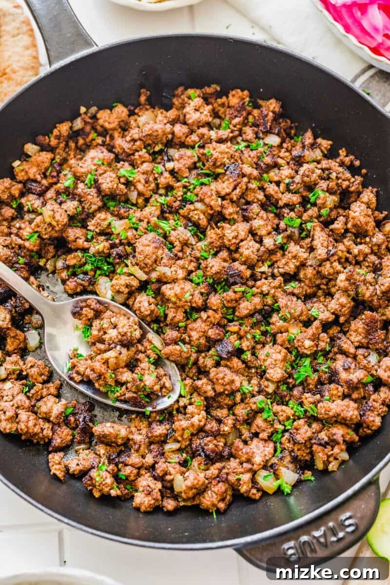 Levantine Spiced Beef Bowls 4 Vibrant green parsley garnishes a pan filled with cooked, spiced ground beef, ready for assembly.