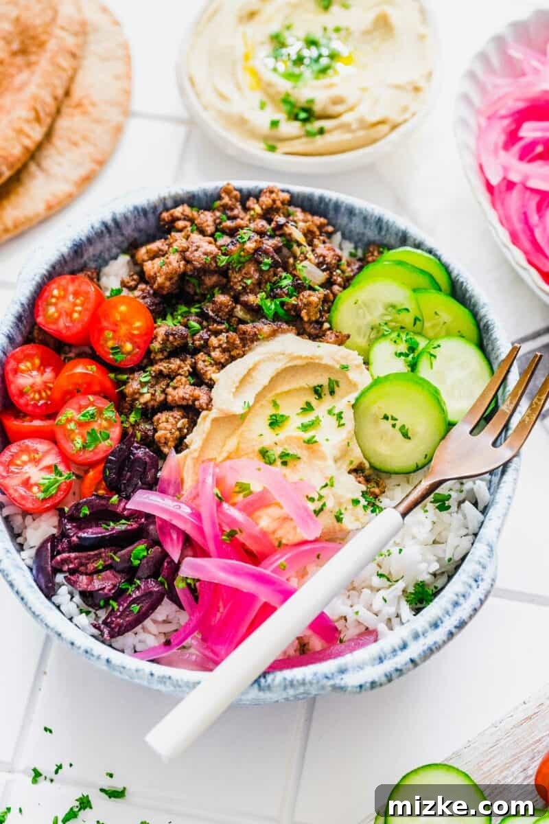 Levantine Spiced Beef Bowls 5 A vibrant and colorful Middle Eastern inspired ground beef bowl, showcasing fresh vegetables and toppings.