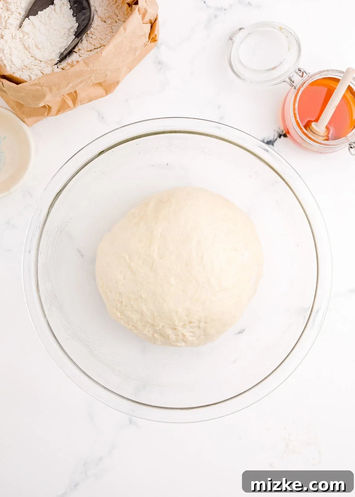 Chewy Homemade Bagels From Scratch 9 Freshly kneaded bagel dough placed in a clear bowl, ready for its first rise.