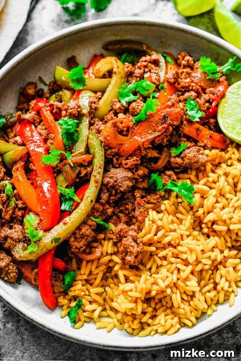 Sizzling Ground Beef Fajitas 5 Rice and ground beef fajitas are topped with a sprinkle of fresh cilantro, ready to be served.