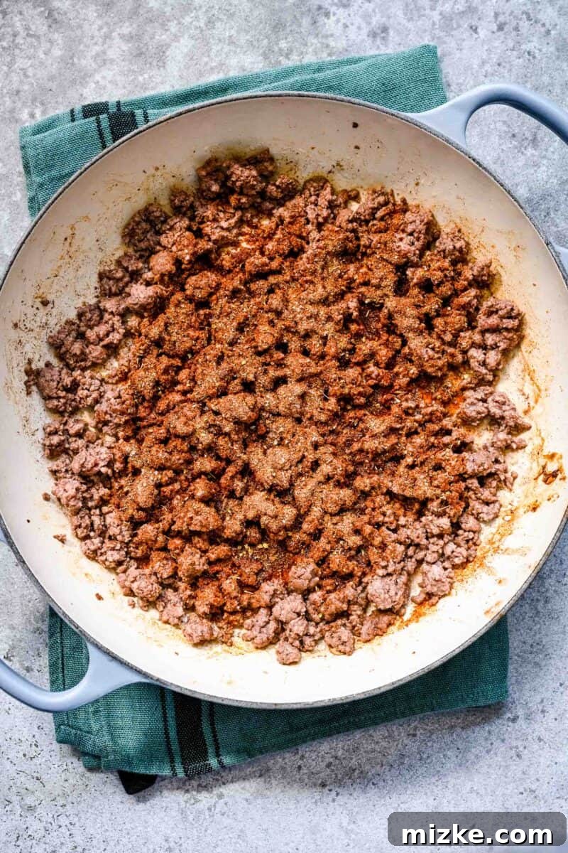 Sizzling Ground Beef Fajitas 7 Adding homemade fajita seasoning to the ground beef mixture in the cast iron skillet, coating it evenly.