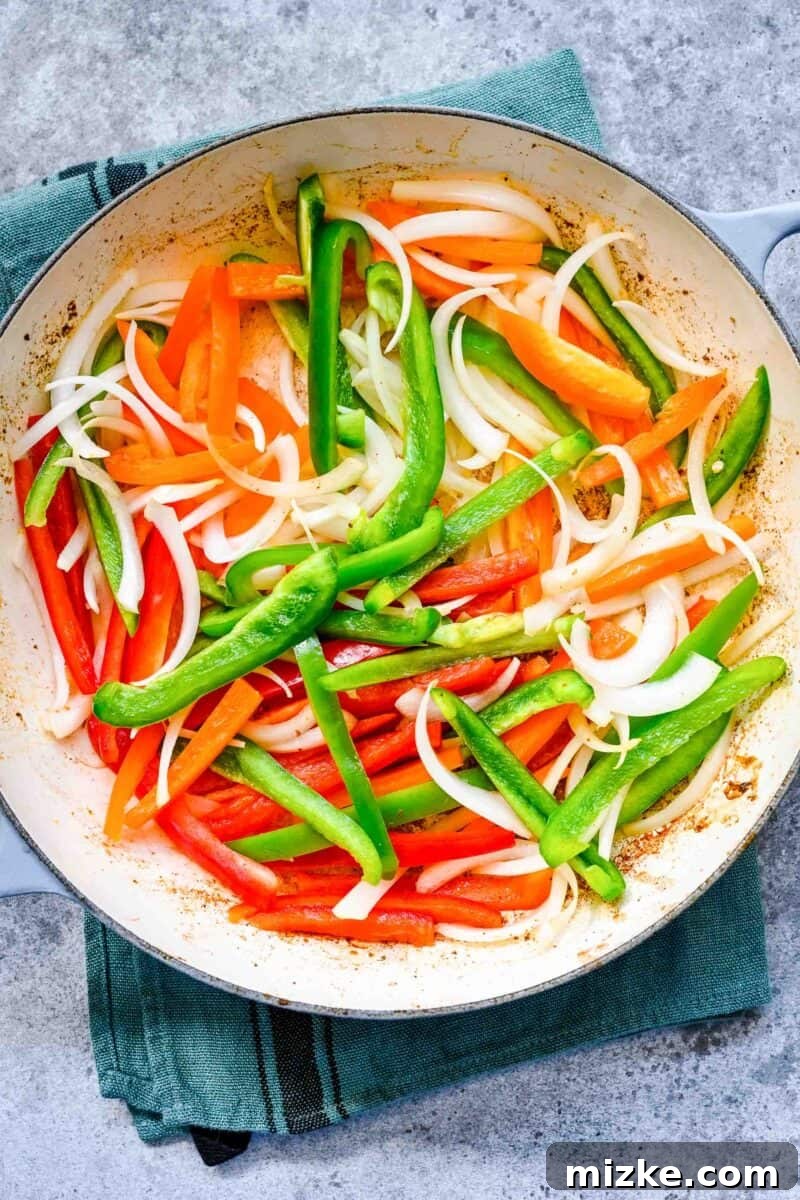 Sizzling Ground Beef Fajitas 8 Adding vibrant bell peppers and thinly sliced onions into a hot cast iron skillet to begin sautéing.