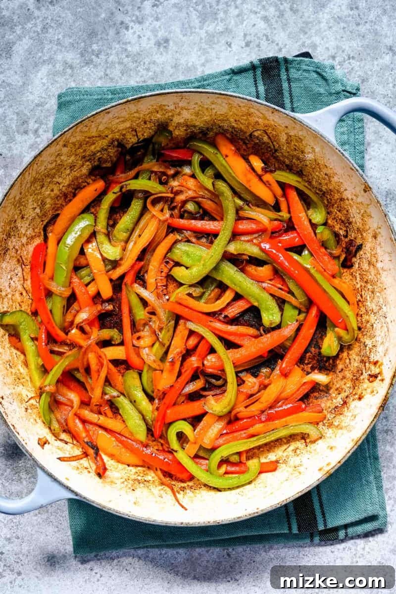 Sizzling Ground Beef Fajitas 9 Cooked down fajita vegetables, tender and slightly charred, in a cast iron skillet, ready to be combined with the beef.