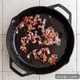 bacon frying in a cast iron skillet