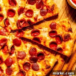 Zesty Pepperoni Pie 4 A beautifully baked and sliced pepperoni pizza, showcasing its crispy crust and perfectly melted cheese, ready to be served.