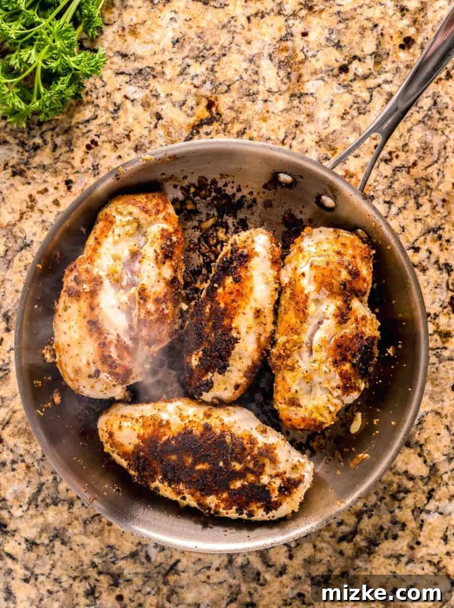 Creamy Garlic Parmesan Chicken Pasta 5 seared and browned chicken breasts in a stainless steel skillet