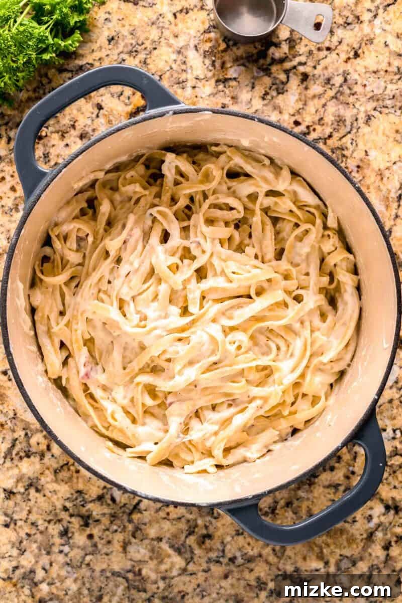 Creamy Garlic Parmesan Chicken Pasta 10 pasta tossed together in the cream sauce in a blue dutch oven
