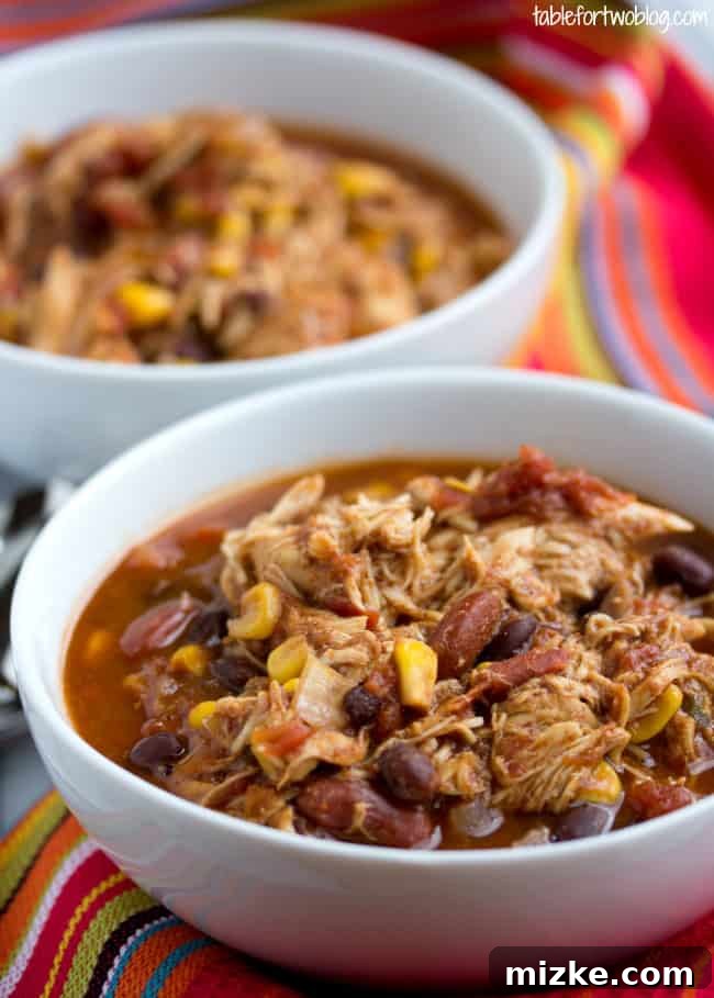 Hearty Crockpot Chicken Taco Chili for a cozy meal A steaming bowl of Crockpot Chicken Taco Chili, garnished with fresh cilantro and shredded cheese.