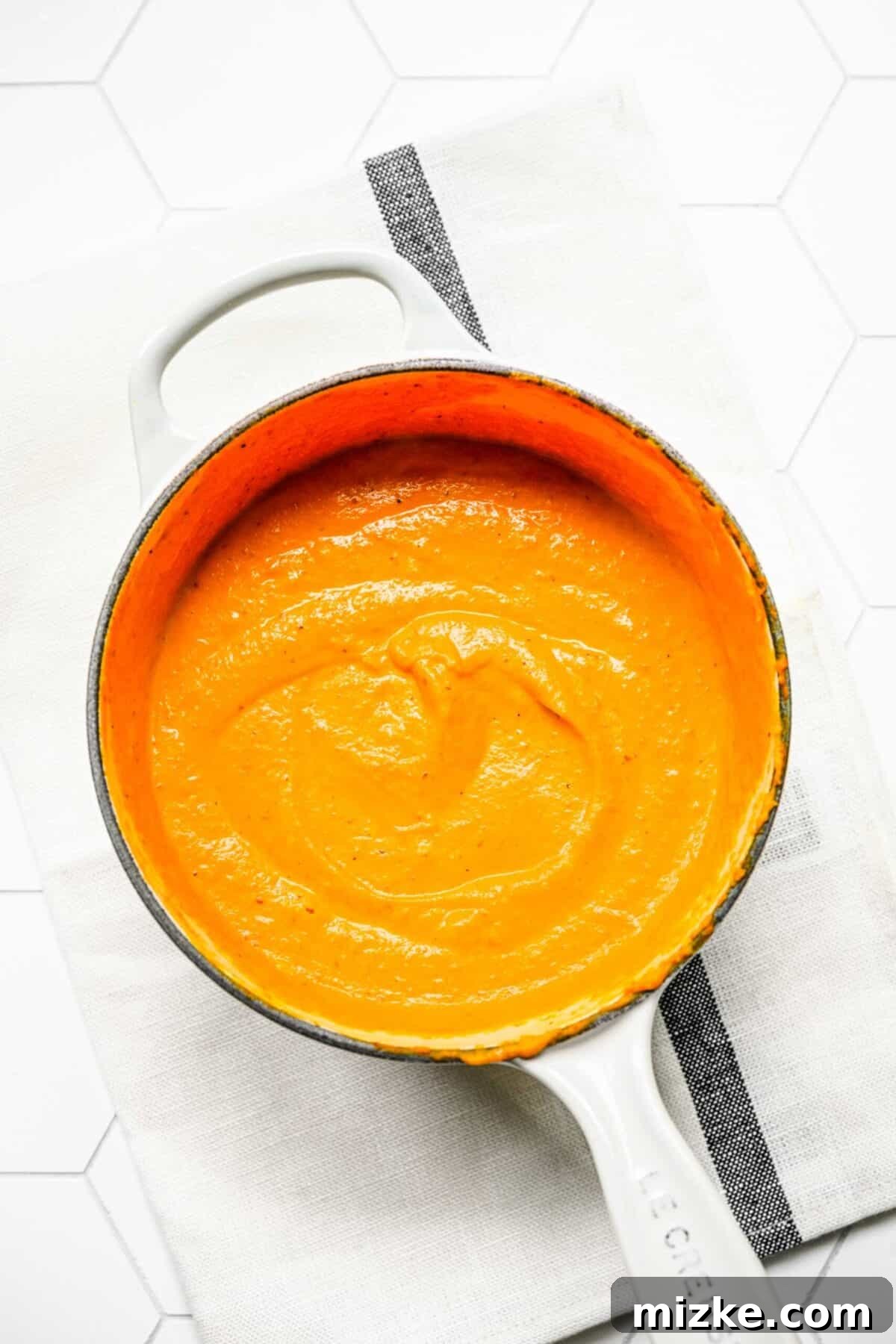 Velvety pumpkin cream sauce, perfectly prepared A saucepan filled with creamy, thickened pumpkin cream sauce
