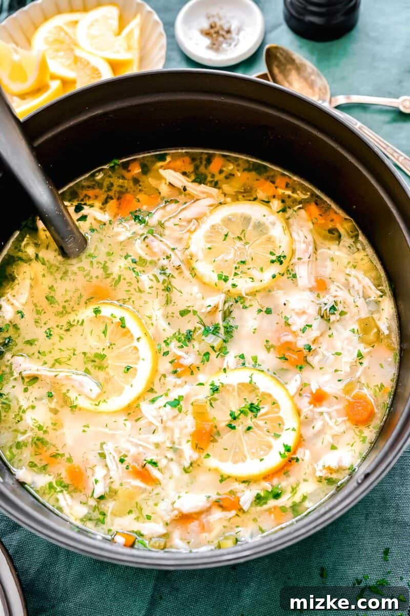 Zesty Lemon Chicken Rice Soup 2 Overhead shot of vibrant lemon chicken and rice soup in a large pot, steam gently rising