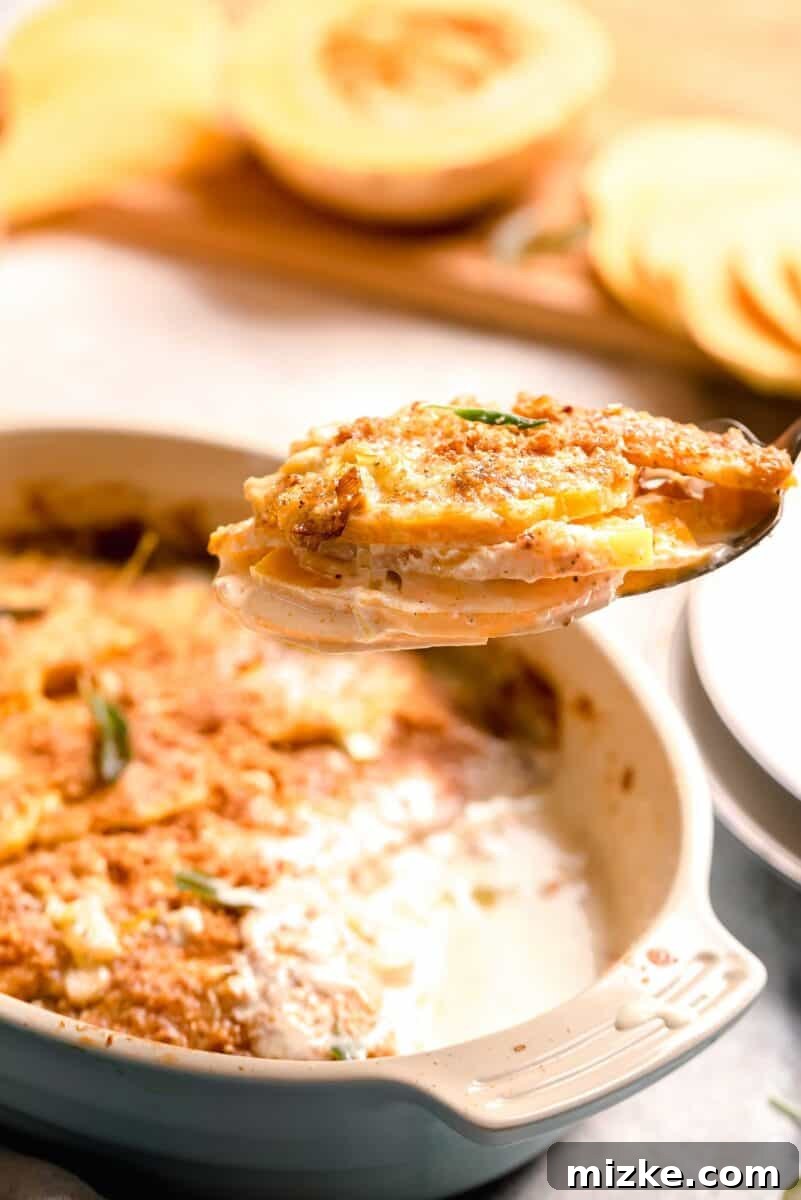 Golden Butternut Bake 6 a large spoonful of butternut squash gratin is shown and you can see the beautiful layers and the cream sauce between.