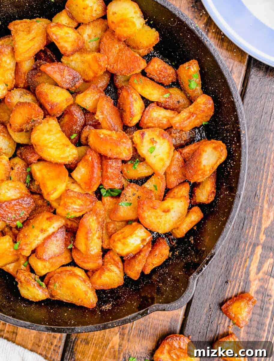 Shatteringly Crisp Duck Fat Potatoes 3 Close-up overhead shot of golden-brown duck fat potatoes nestled on a wooden background, showcasing their crisp texture