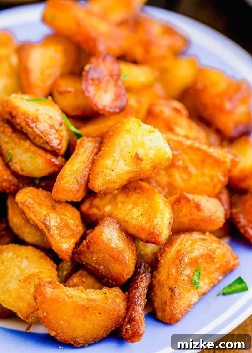 Shatteringly Crisp Duck Fat Potatoes 4 Macro shot highlighting the golden-brown, textured, and incredibly crispy exterior of a single duck fat potato